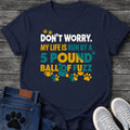 Multicolor graphic tee design reading "Don't Worry, My Life Is Run by a 5 Pound Ball of Fuzz," in white, gold, and teal type surrounded by paw prints.