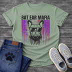 French Bulldog t-shirt with bold black block text reading Bat Ear Mafia above a Frenchie portrait wearing sunglasses, purple and orange glitch data drip background, black ink dripping below, high impact streetwear graphic
