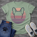 French Bulldog t-shirt with minimal brush ink Frenchie head seen from behind, bold bat ears outlined against a retro striped circle sunset in blush pink mauve and deep purple tones, distressed vintage texture, no text fine art graphic
