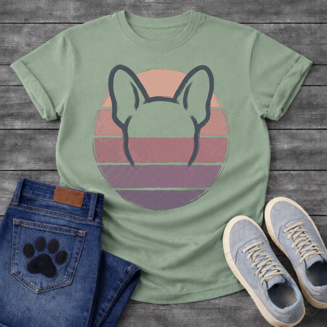 French Bulldog t-shirt with minimal brush ink Frenchie head seen from behind, bold bat ears outlined against a retro striped circle sunset in blush pink mauve and deep purple tones, distressed vintage texture, no text fine art graphic
