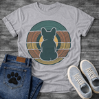 French Bulldog t-shirt with Frenchie silhouette seen from behind centered in layered concentric rings of teal terracotta and gold that bend and wrap around the figure, golden circle glowing behind, no text, bold retro graphic art