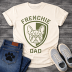 French Bulldog t-shirt with military style shield badge containing a geometric Frenchie face portrait, stencil font arched text reading Frenchie above and Dad below, single olive green ink graphic