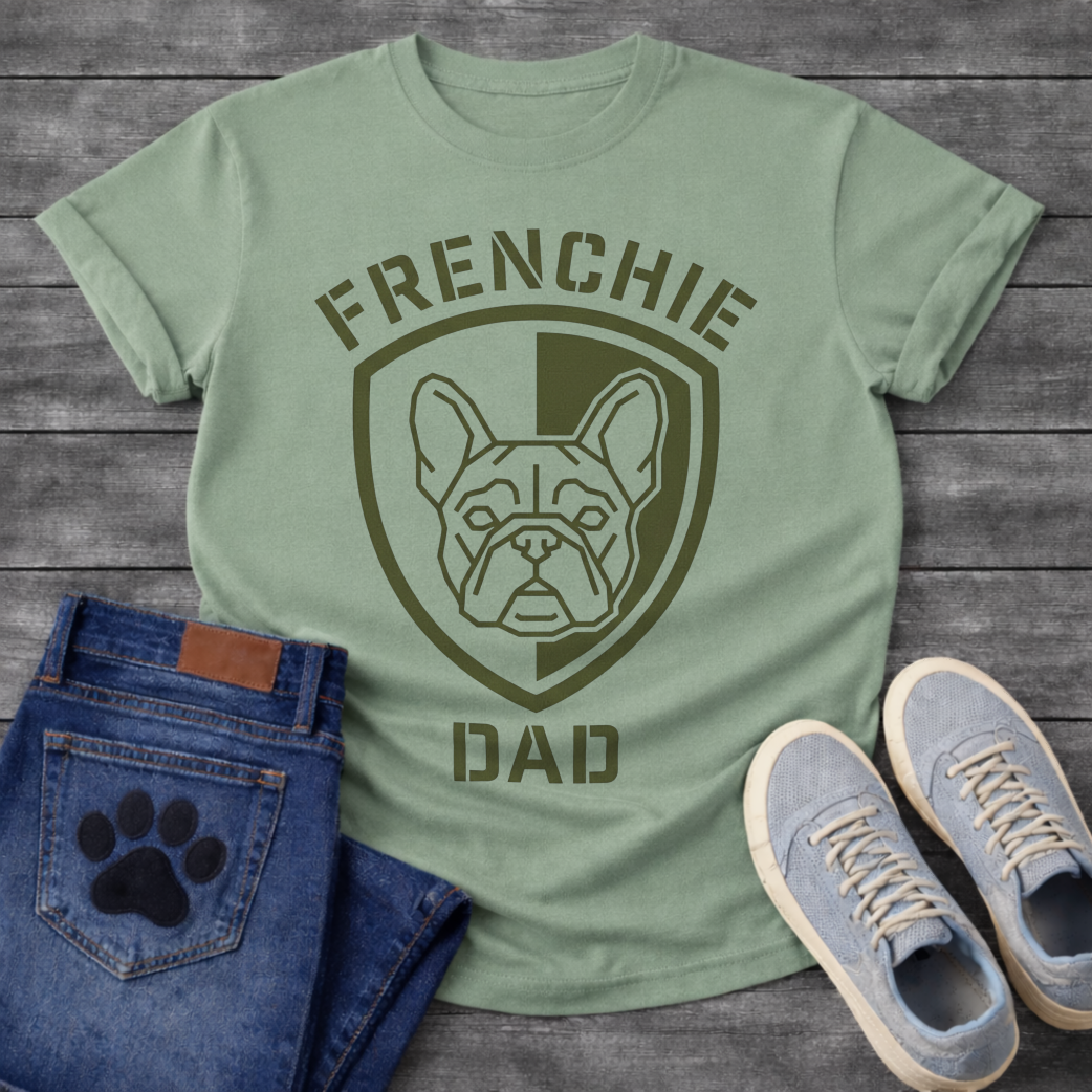 French Bulldog t-shirt with military style shield badge containing a geometric Frenchie face portrait, stencil font arched text reading Frenchie above and Dad below, single olive green ink graphic
