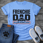 French Bulldog t-shirt with oversized bold typography reading Frenchie Dad, splooting Frenchie illustration tucked between the letters, orange bordered banner below reading Selective Hearing Expert, black and orange graphic design