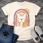 French Bulldog t-shirt with peaceful Frenchie face eyes closed centered in a boho rainbow arch, wildflower and botanical line art on either side, muted purple terracotta gold and cream tones, abstract circles in background, soft boho illustration no text