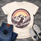 French Bulldog t-shirt with circular badge illustration, Frenchie silhouette sitting on a rocky trail surrounded by pine trees and mountain peaks, retro sunset stripe arch above in terracotta and gold, deep plum border, distressed vintage texture, no text