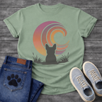 French Bulldog t-shirt with Frenchie silhouette seen from behind sitting in grass and reeds, facing a large swirling spiral sunset in pink orange purple and yellow gradient tones, painterly vintage illustration graphic