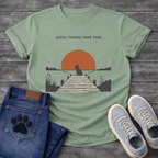 French Bulldog t-shirt with Frenchie silhouette sitting on a wooden dock facing a large terracotta sunset over water, reeds and shoreline on either side, text above reading Good Things Take Time, two-color vintage landscape illustration