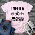 French Bulldog t-shirt with bold collegiate typography reading I Need a Frenchie Translator, black Frenchie face silhouette flanked by sound wave graphics, single dark ink on warm sand tee, clean graphic design