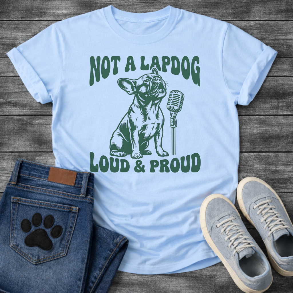 French Bulldog t-shirt with retro groovy arched text reading Not a Lapdog above a detailed Frenchie illustration mid-vocalization beside a vintage microphone, bold text below reading Loud and Proud, single forest green ink graphic