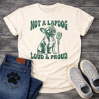 French Bulldog t-shirt with retro groovy arched text reading Not a Lapdog above a detailed Frenchie illustration mid-vocalization beside a vintage microphone, bold text below reading Loud and Proud, single forest green ink graphic