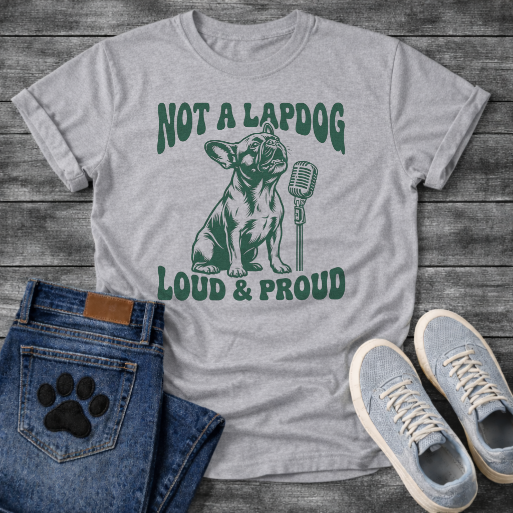 French Bulldog t-shirt with retro groovy arched text reading Not a Lapdog above a detailed Frenchie illustration mid-vocalization beside a vintage microphone, bold text below reading Loud and Proud, single forest green ink graphic