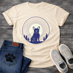 French Bulldog silhouette seated in front of a full moon with concentric rings and pine trees, navy and cream circular badge graphic tee