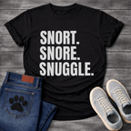 Snort Snore Snuggle bold white typography graphic tee on black