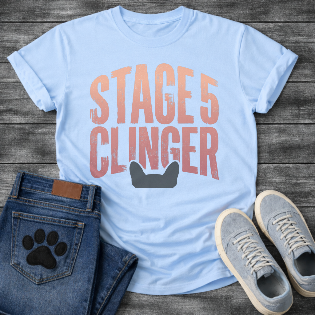 French Bulldog t-shirt with oversized distressed brush typography reading Stage 5 Clinger in dusty rose and mauve tones, small Frenchie head silhouette peeking up from the bottom of the design, no text graphic