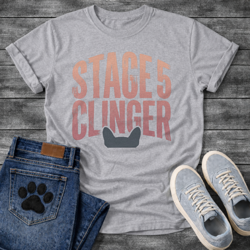 French Bulldog t-shirt with oversized distressed brush typography reading Stage 5 Clinger in dusty rose and mauve tones, small Frenchie head silhouette peeking up from the bottom of the design, no text graphic