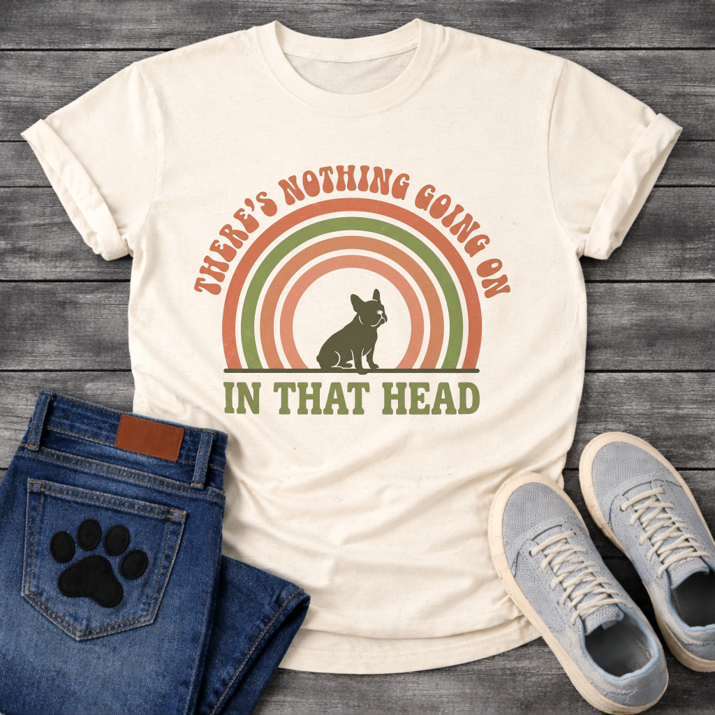 Retro 70s French Bulldog t-shirt with arched groovy text reading There's Nothing Going On In That Head, Frenchie silhouette centered in concentric terracotta and olive green rainbow arcs, vintage distressed style