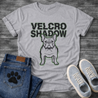 French Bulldog t-shirt with oversized bold black text reading Velcro Shadow above a detailed Frenchie portrait with neon green outline, black and green two-color streetwear graphic