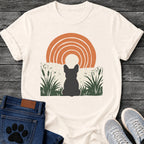 French Bulldog t-shirt with Frenchie silhouette seen from behind sitting in dark green botanical cattails and grass, cream circle moon rising behind the head, bold concentric terracotta arch above, distressed torn edge ground texture, no text boho art graphic
