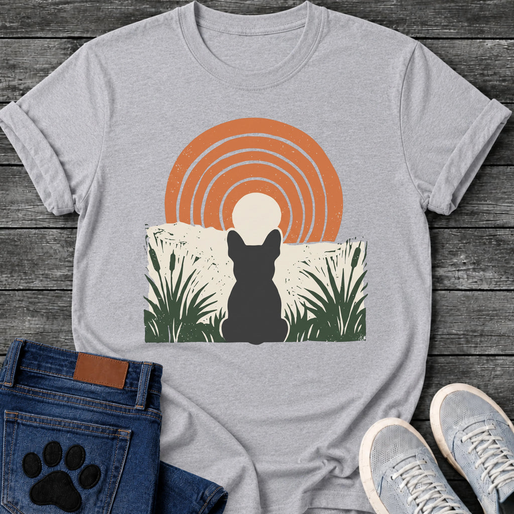 French Bulldog t-shirt with Frenchie silhouette seen from behind sitting in dark green botanical cattails and grass, cream circle moon rising behind the head, bold concentric terracotta arch above, distressed torn edge ground texture, no text boho art graphic
