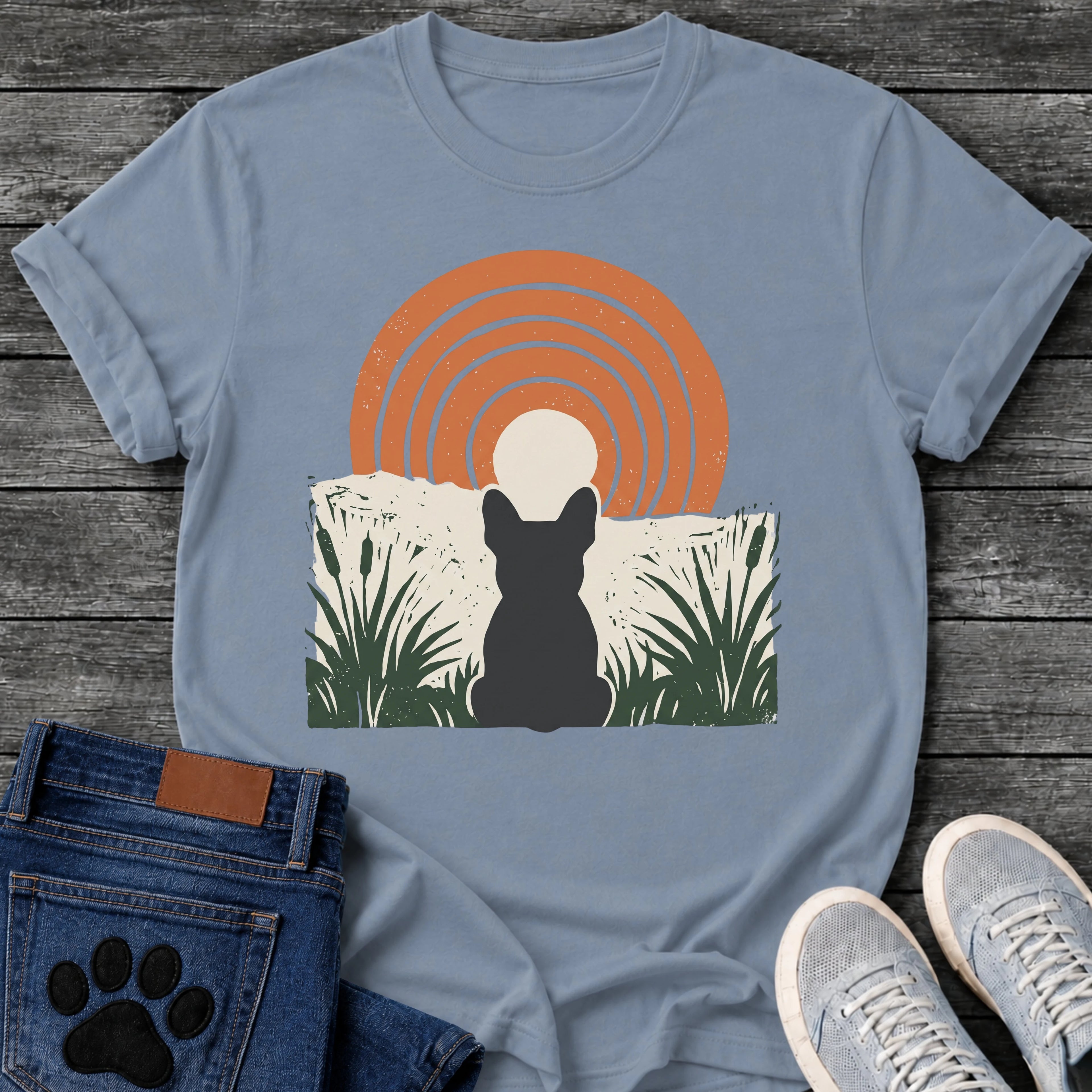 French Bulldog t-shirt with Frenchie silhouette seen from behind sitting in dark green botanical cattails and grass, cream circle moon rising behind the head, bold concentric terracotta arch above, distressed torn edge ground texture, no text boho art graphic
