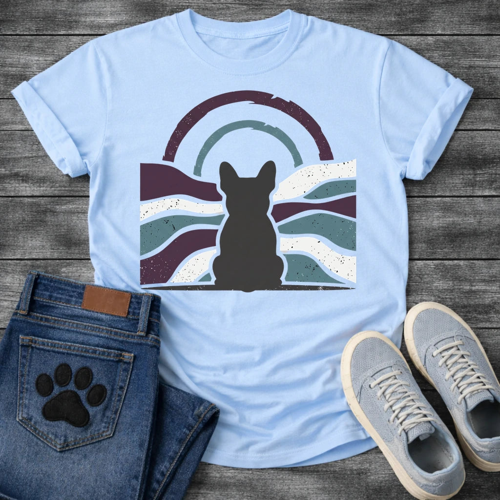 French Bulldog t-shirt with Frenchie silhouette seen from behind centered in a distressed wavy landscape of deep plum teal and cream, double concentric arch with arrow detail above, heavy vintage texture throughout, no text moody art graphic