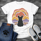 French Bulldog t-shirt with Frenchie silhouette seen from behind centered in a layered organic landscape of terracotta gold and soft purple flowing forms, color rippling in a water reflection below, no text warm painterly art graphic