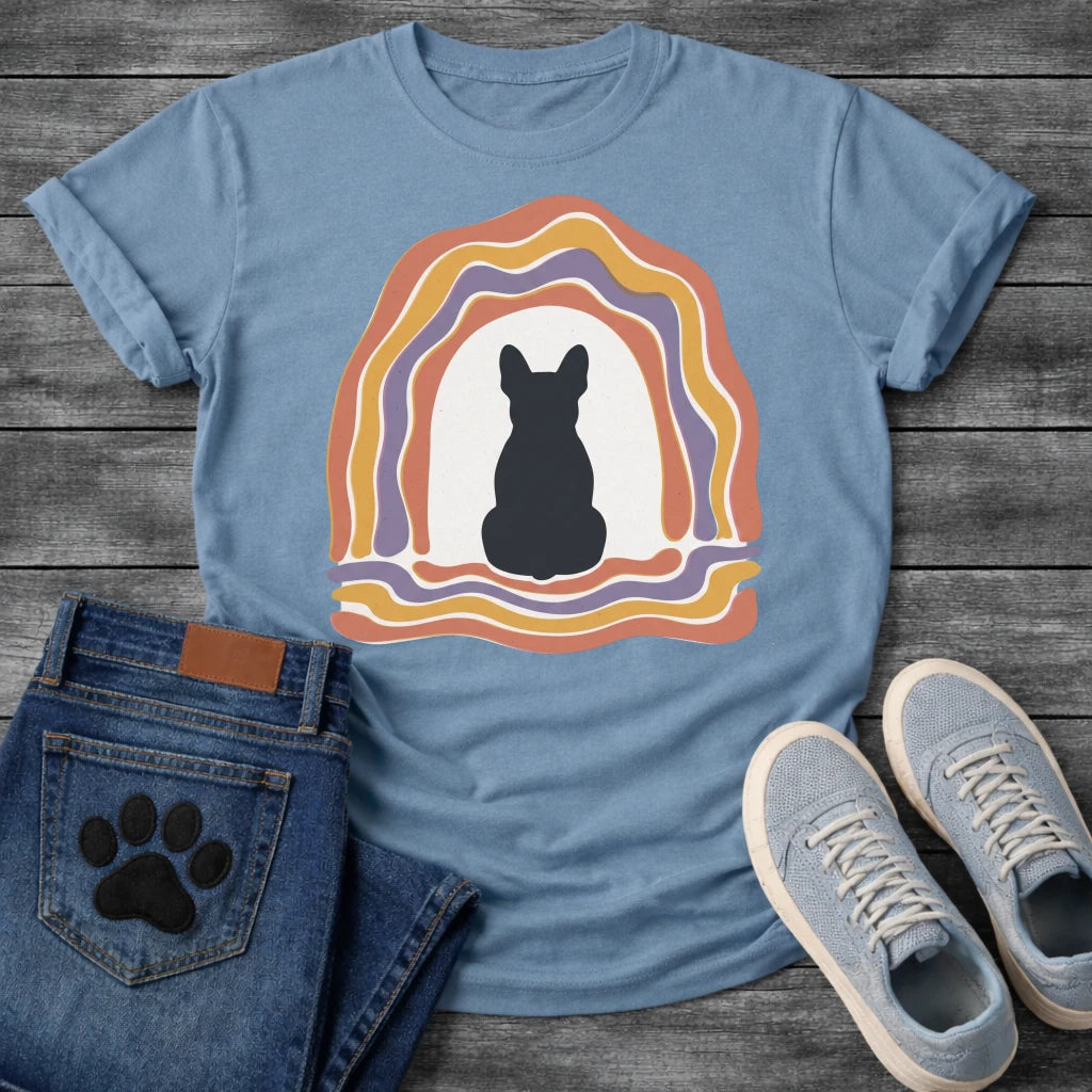 French Bulldog t-shirt with Frenchie silhouette seen from behind centered in a cream open space, surrounded by layered organic concentric arch in terracotta gold and soft purple, wavy lines trailing below, no text soft boho art graphic
