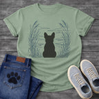 French Bulldog t-shirt with Frenchie silhouette seen from behind centered in a wide open navy line art botanical scene, tall reeds and cattails sweeping in from both sides, rippling water and distant mountain horizon ahead, no text refined nature illustration