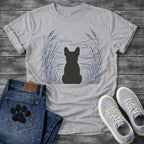 French Bulldog t-shirt with Frenchie silhouette seen from behind centered in a wide open navy line art botanical scene, tall reeds and cattails sweeping in from both sides, rippling water and distant mountain horizon ahead, no text refined nature illustration