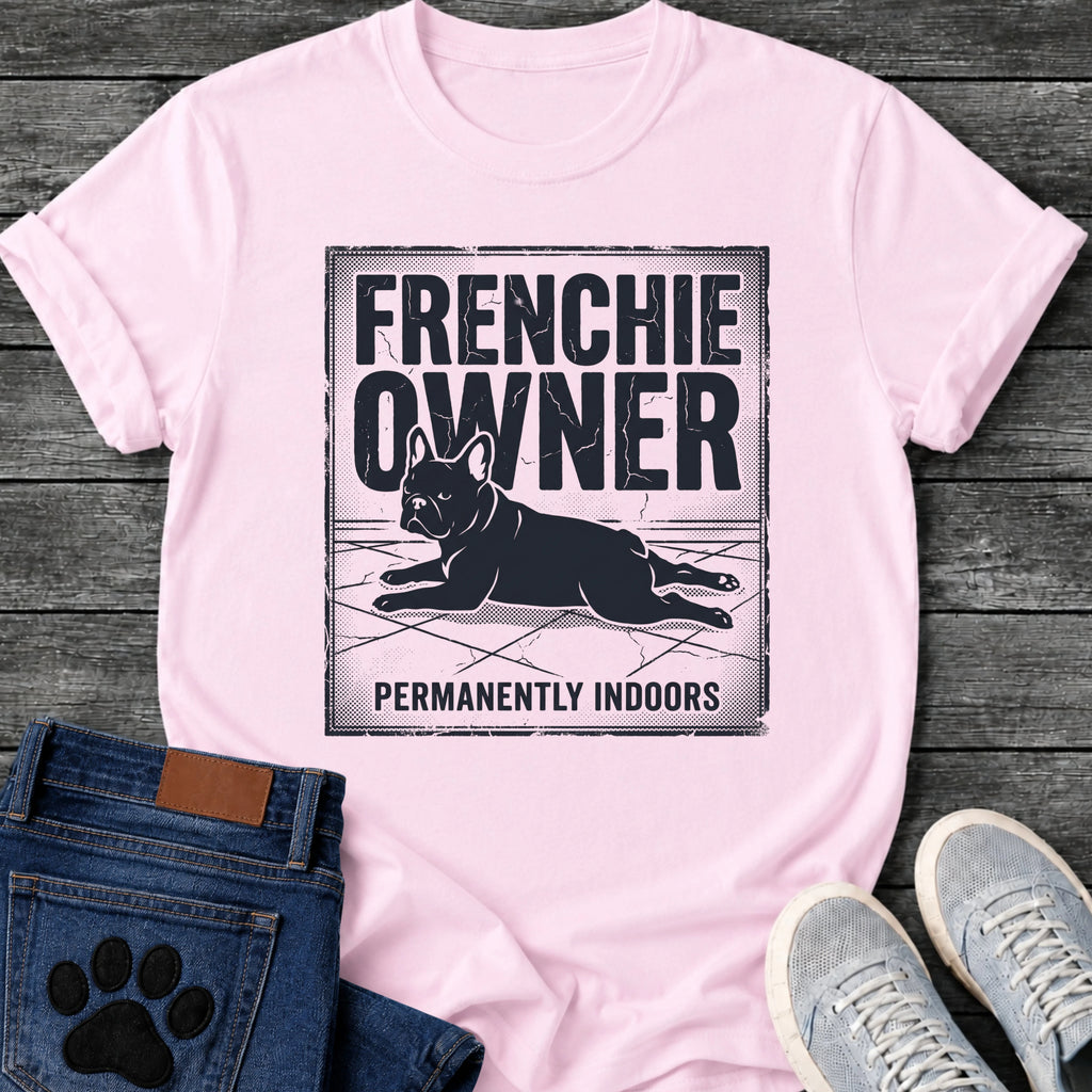 French Bulldog t-shirt with vintage distressed poster frame, bold oversized text reading Frenchie Owner above a splooting Frenchie lying flat on tile floor, bold banner text below reading Permanently Indoors, single dark ink halftone graphic with heavy crackle texture