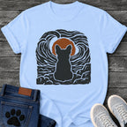 French Bulldog t-shirt with Frenchie silhouette seen from behind sitting on cracked rock, bold swirling woodcut style sky in black and cream surrounding a terracotta moon, heavy linocut print texture throughout, no text dramatic art graphic
