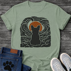 French Bulldog t-shirt with Frenchie silhouette seen from behind sitting on cracked rock, bold swirling woodcut style sky in black and cream surrounding a terracotta moon, heavy linocut print texture throughout, no text dramatic art graphic
