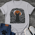 French Bulldog t-shirt with Frenchie silhouette seen from behind sitting on cracked rock, bold swirling woodcut style sky in black and cream surrounding a terracotta moon, heavy linocut print texture throughout, no text dramatic art graphic
