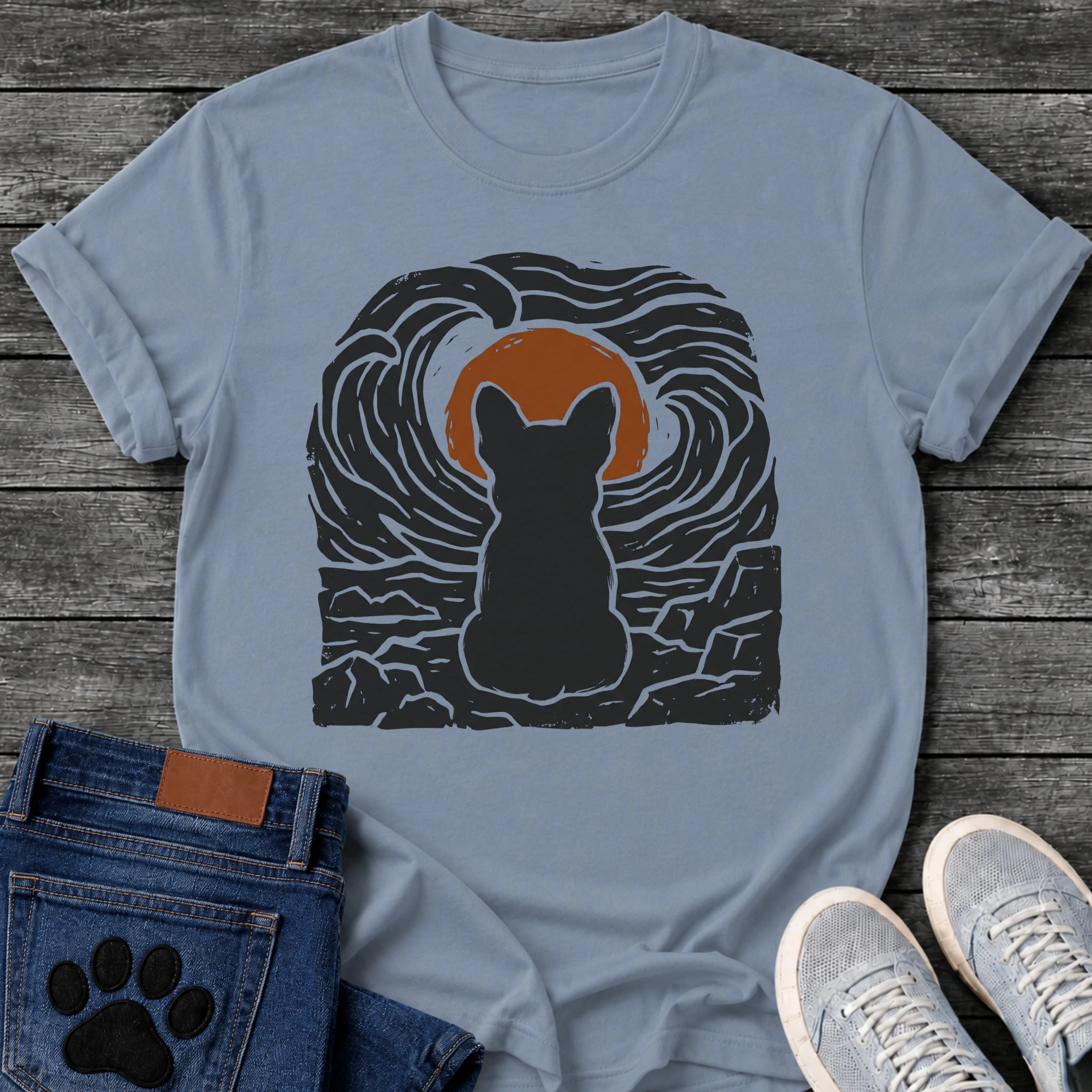 French Bulldog t-shirt with Frenchie silhouette seen from behind sitting on cracked rock, bold swirling woodcut style sky in black and cream surrounding a terracotta moon, heavy linocut print texture throughout, no text dramatic art graphic
