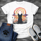 French Bulldog t-shirt with Frenchie silhouette seen from behind in ink wash cattails and grass, full watercolor sunset in coral gold and deep purple behind, loose concentric brushstroke rainbow arch above, no text painterly watercolor art graphic