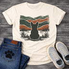French Bulldog t-shirt with Frenchie silhouette seen from behind with cream outline sitting in grass and shallow water, bold woodcut style wavy landscape in forest green and terracotta behind, heavy distressed texture throughout, no text earthy art graphic