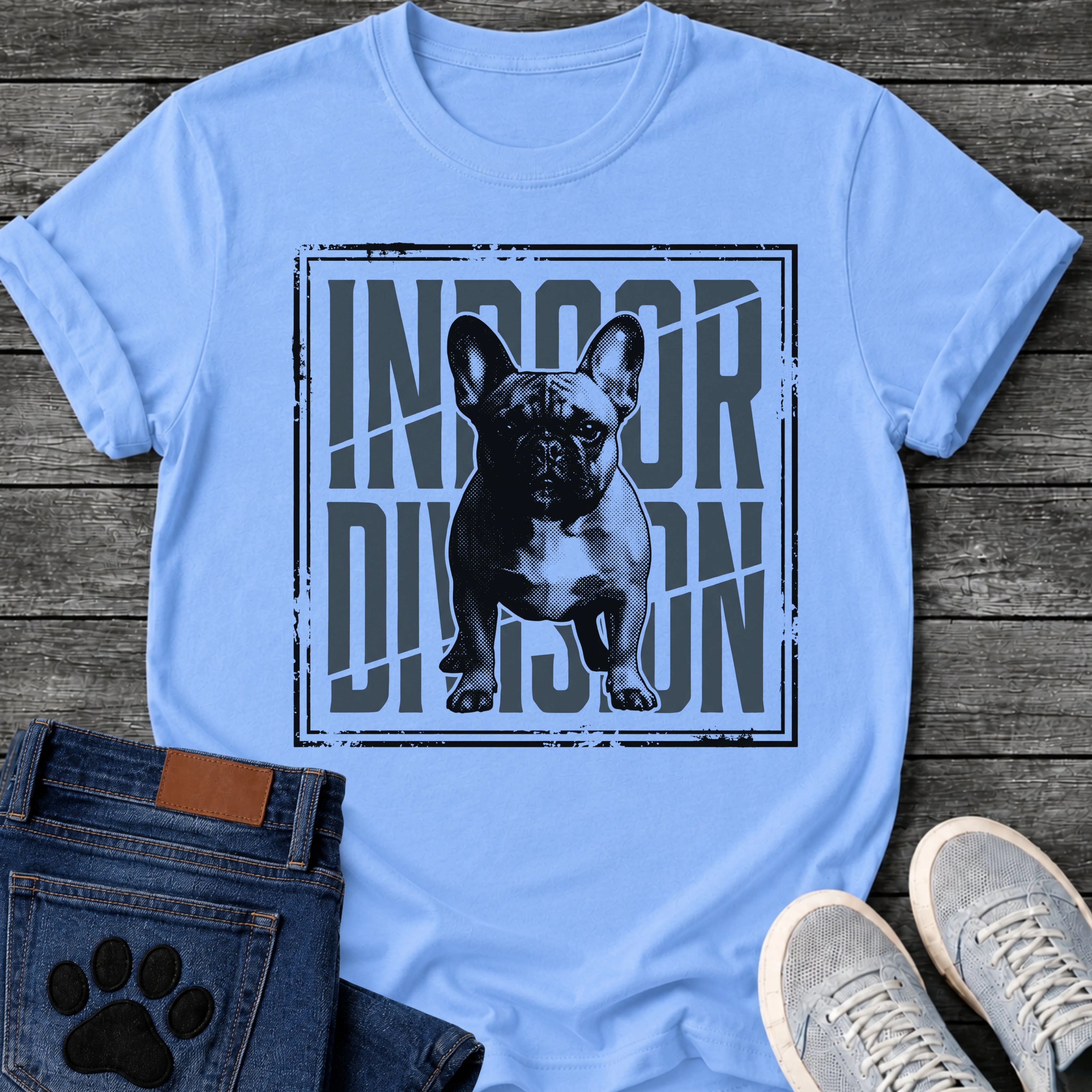 French Bulldog t-shirt with halftone Frenchie standing full body facing forward, oversized condensed slate blue text reading Indoor Division behind the portrait, diagonal slash detail, heavy distressed double border frame, black and slate two-color graphic
