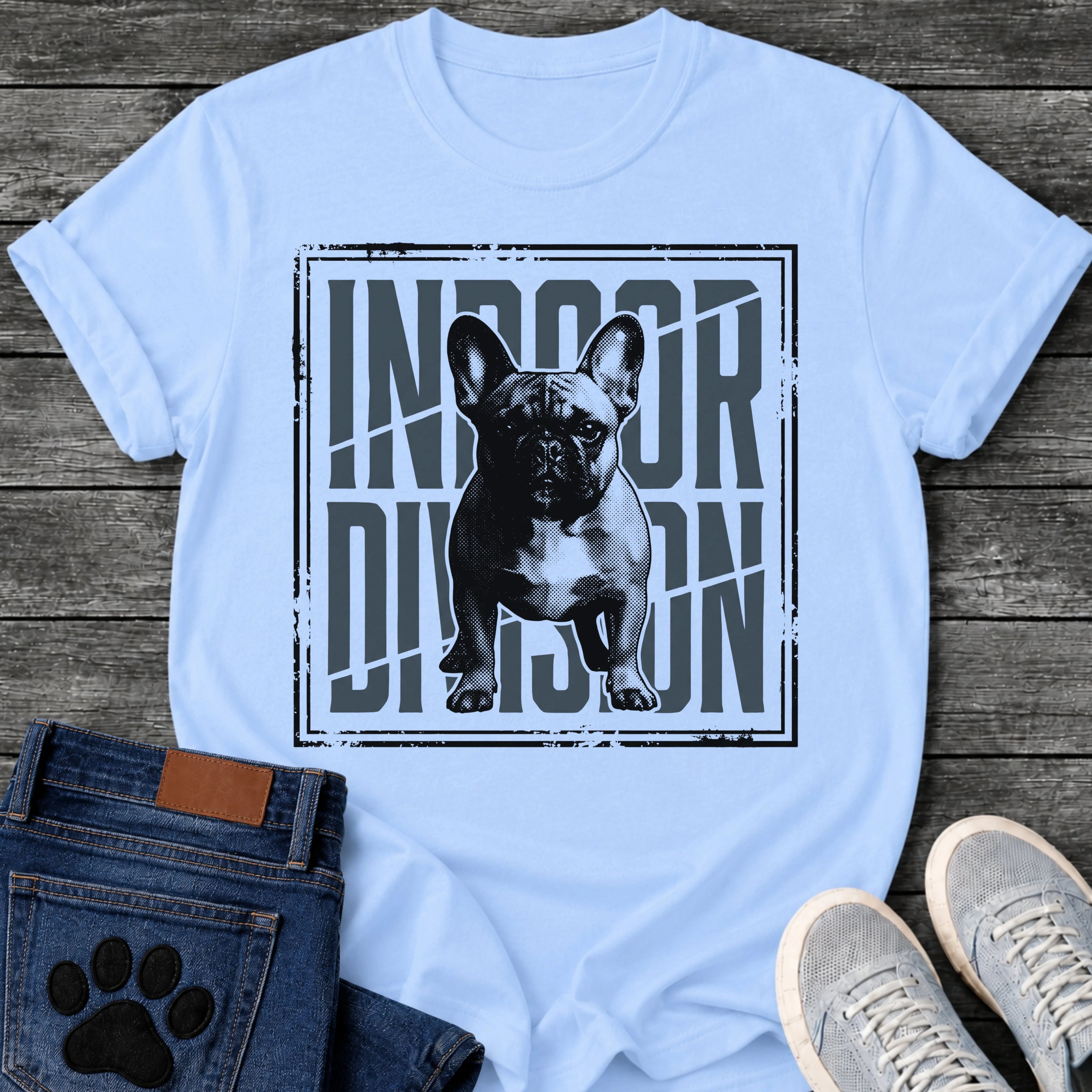 French Bulldog t-shirt with halftone Frenchie standing full body facing forward, oversized condensed slate blue text reading Indoor Division behind the portrait, diagonal slash detail, heavy distressed double border frame, black and slate two-color graphic
