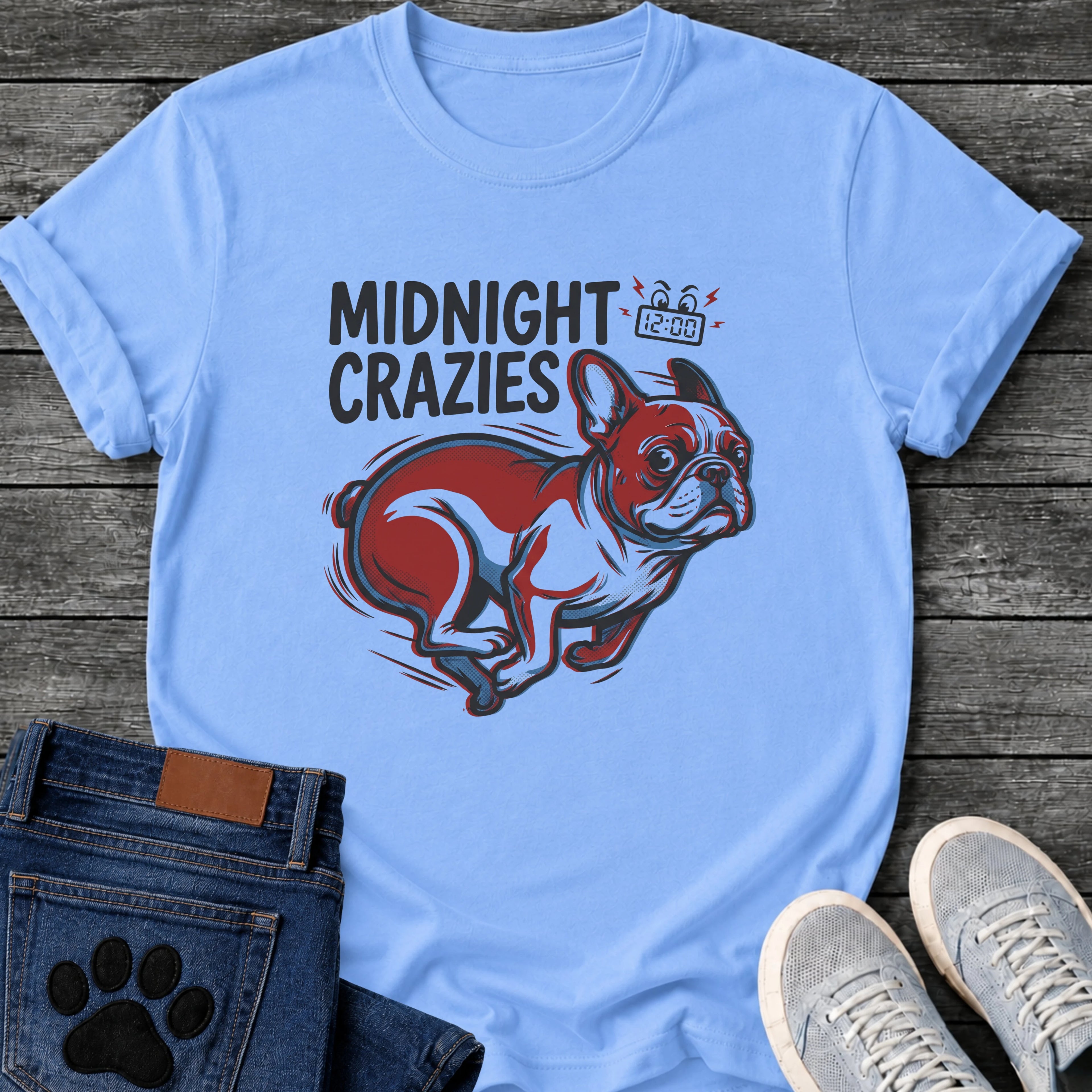 French Bulldog t-shirt with bold retro comic text reading Midnight Crazies upper left, animated alarmed clock showing 12:00 with lightning bolts and cartoon eyes, large red and blue halftone Frenchie running at full speed, speed lines throughout