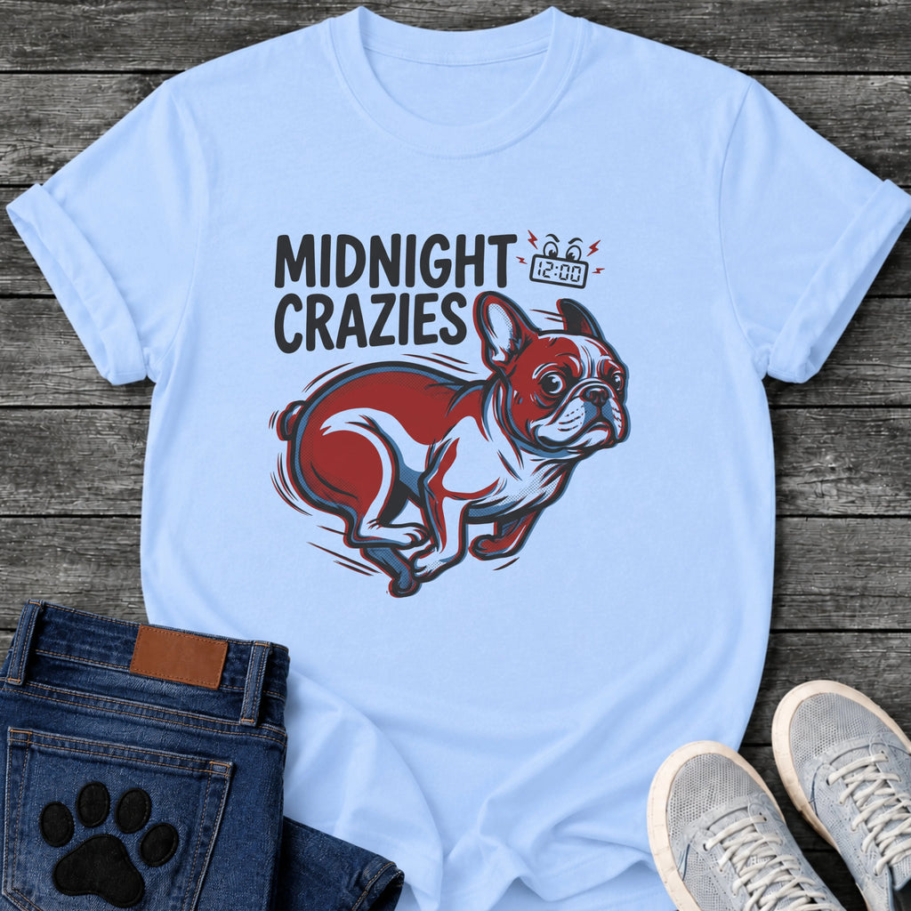 French Bulldog t-shirt with bold retro comic text reading Midnight Crazies upper left, animated alarmed clock showing 12:00 with lightning bolts and cartoon eyes, large red and blue halftone Frenchie running at full speed, speed lines throughout