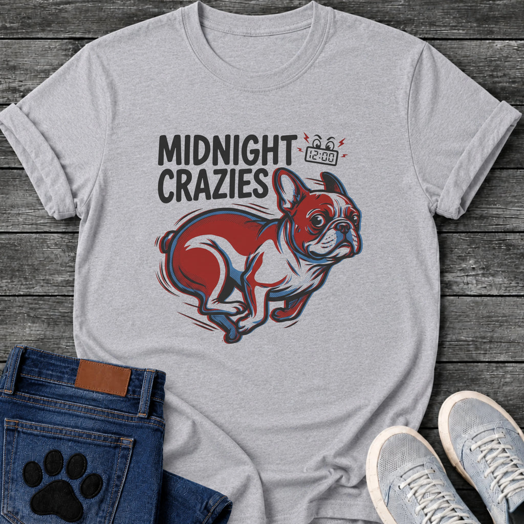 French Bulldog t-shirt with bold retro comic text reading Midnight Crazies upper left, animated alarmed clock showing 12:00 with lightning bolts and cartoon eyes, large red and blue halftone Frenchie running at full speed, speed lines throughout