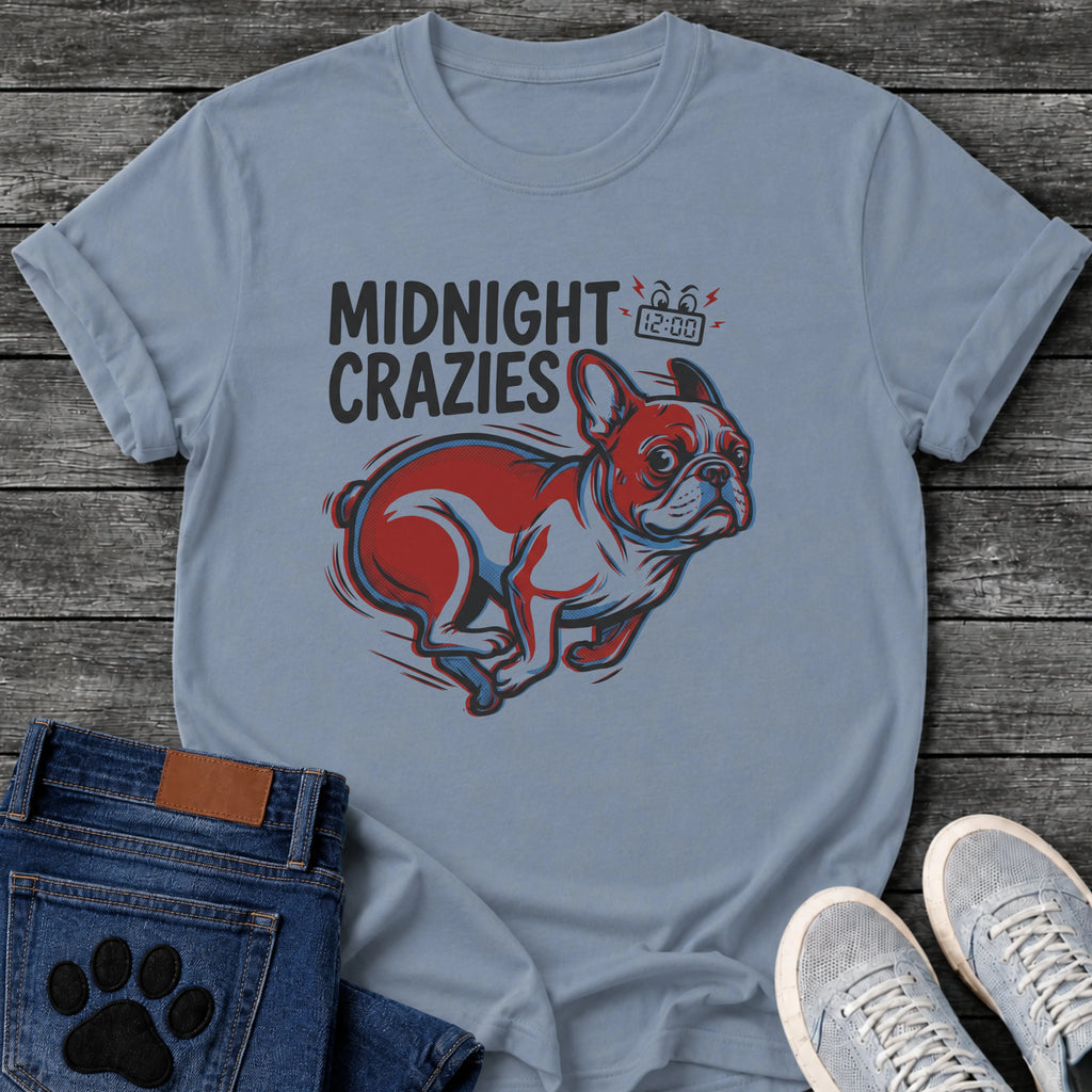 French Bulldog t-shirt with bold retro comic text reading Midnight Crazies upper left, animated alarmed clock showing 12:00 with lightning bolts and cartoon eyes, large red and blue halftone Frenchie running at full speed, speed lines throughout