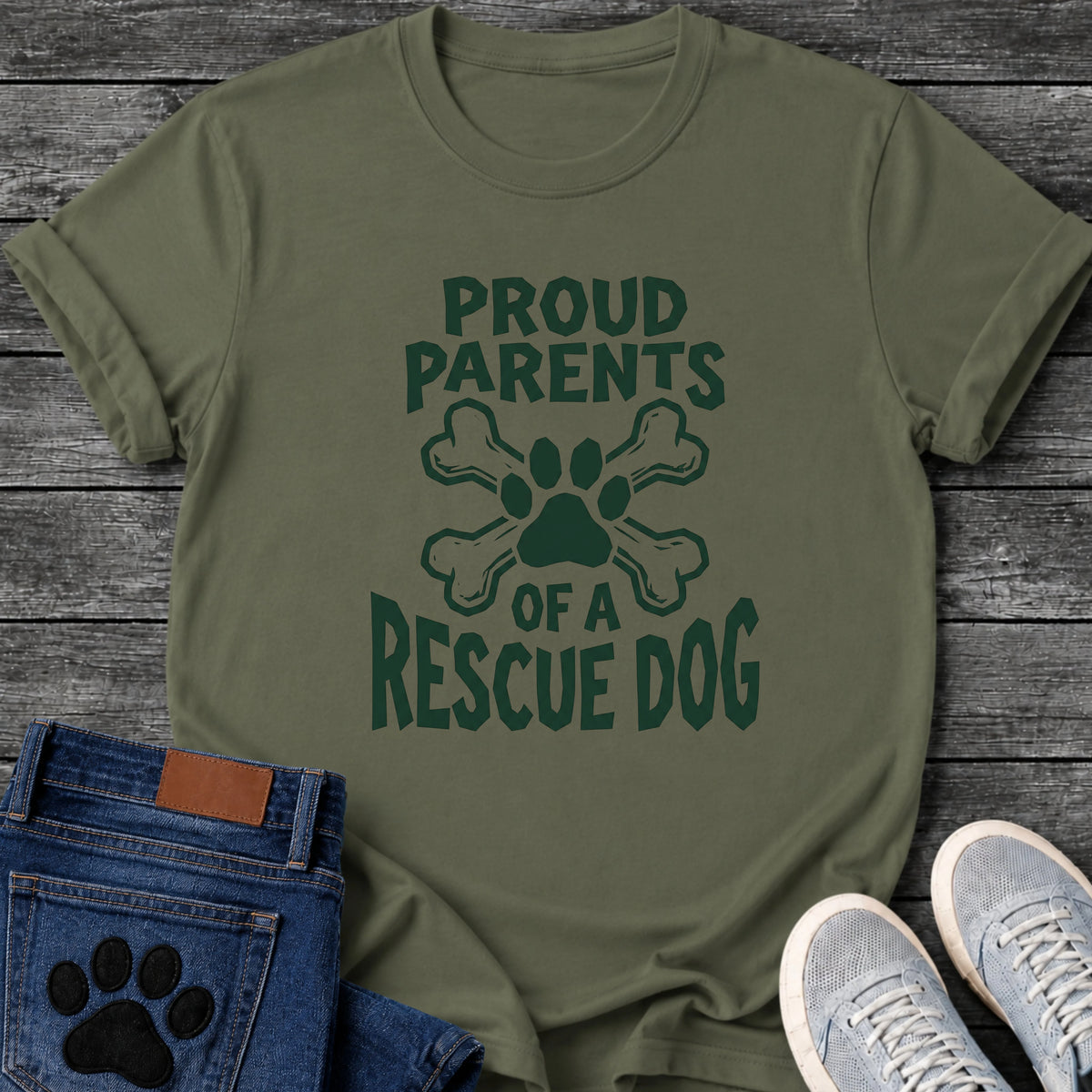 Proud Parents Of A Rescue Dog t shirt design in dark green text with a paw print and crossbones icon