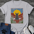 Sport GreyFrench Bulldog t-shirt with Frenchie silhouette seen from behind sitting on contoured red rock, large gold sun against slate blue sky, red canyon walls on either side, forest green ferns in foreground, distressed woodcut border frame, no text national park style art graphic