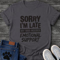 Bold mixed type graphic tee design reading "Sorry I'm Late, My Dog Needed Emotional Support," with a stamped highlight bar behind the middle line.