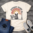 French Bulldog t-shirt with stencil arched text reading Street Punk above a spray paint scene of a Frenchie sitting on a park bench beside a street lamp, zigzag spray paint rainbow in red terracotta and gold with drips, urban street art graphic