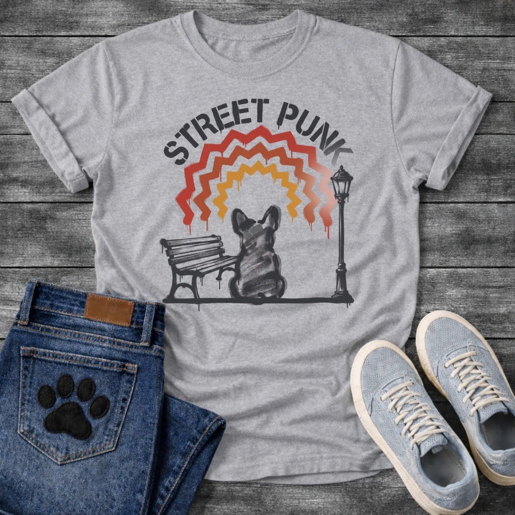French Bulldog t-shirt with stencil arched text reading Street Punk above a spray paint scene of a Frenchie sitting on a park bench beside a street lamp, zigzag spray paint rainbow in red terracotta and gold with drips, urban street art graphic