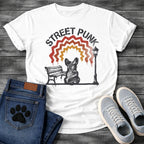French Bulldog t-shirt with stencil arched text reading Street Punk above a spray paint scene of a Frenchie sitting on a park bench beside a street lamp, zigzag spray paint rainbow in red terracotta and gold with drips, urban street art graphic