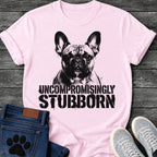 French Bulldog t-shirt with high contrast halftone Frenchie portrait facing forward with ink splatter drip details, bold oversized stencil text below reading Uncompromisingly Stubborn, single black ink graphic with serious streetwear energy
